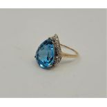 A 9ct. gold, diamond and blue topaz cocktail ring, claw set mixed pendeloque cut blue topaz to