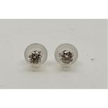 A pair of platinum diamond stud earrings, each claw set single round brilliant cut diamond, post