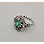 An 18ct. white gold, diamond and emerald ring, claw set mixed pendeloque cut emerald to centre (7.