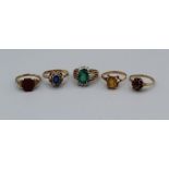 A collection of five 9ct gold and yellow metal rings. Comprising a citrine ring in yellow metal, set