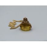 A 9ct gold Victorian buckle spinner fob, set with a yellow paste spinner and along with a 375