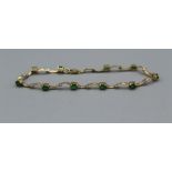 An emerald and diamond set bracelet in yellow metal stamped "14K". Approximate weight 4.7 grams.