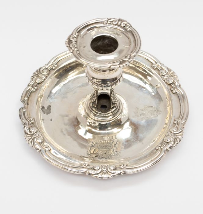 A George III silver chamberstick, the detachable sconce with foliate scrolls, above a waisted and