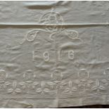 A striking extra large linen bedspread hand embroidered with a Tudor rose border, posy baskets,