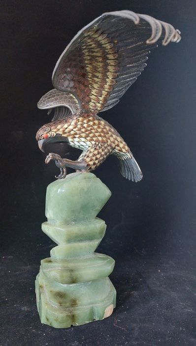 A 925 silver eagle with enamelled decoration, the onyx base modelled as rockwork, 26cm high