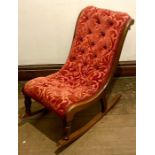 A Victorian mahogany rocking chair with button down upholstery on turned front legs, curved rockers