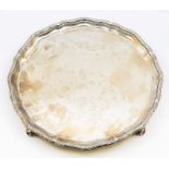 A George V silver salver, raised border with ribbon and reeded decoration, plain reserve on four