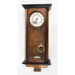 A large wooden cased Viennese wall clock with pendulum and key present.