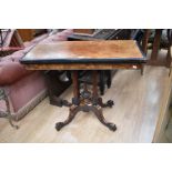 A Burr Walnut games table with four pedestal stilts to a four legged splayed base. Fabric to top