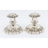 A pair of Victorian dwarf silver plated candlesticks, comprising repousse grape vine and scroll