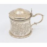 A Victorian silver drum shaped mustard pot and cover, engraved with floral decoration, scallop