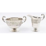 A George V silver two handled sugar bowl on circular pedestal base and with embossed Celtic