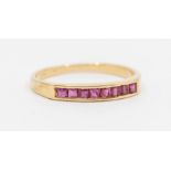 A ruby and 14ct gold half eternity ring, channel set with eight calibre cut rubies each approx 1.