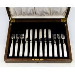 A set of six George V silver and mother-of-pearl handled fruit knives and forks, hallmarked by James