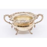 A late Victorian silver two handled sugar bowl, the rim cast with trailing flowers and foliage,
