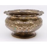 An Edwardian silver bowl with ornate embossed floral design and stylised rim to top, hallmarked