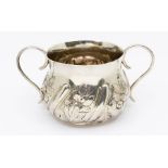 A Victorian Britannia 958 standard silver two handled porringer with embossed floral design,