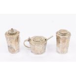 An Art Deco three piece silver condiment set to include: mustard pot and cover, salt and pepper
