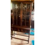 A 20th Century oak display cabinet, glazed panel doors enclosing shelves, on a geometric frieze