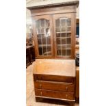 A Queen Anne revival oak glazed bookcase bureau, dental cornice, above twin arch inlay glazed