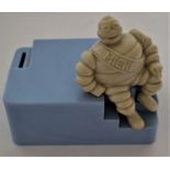 A Michelin bakelite employees money box modelled as a seated Mr. Bibendum to a blue base, 13cm h x