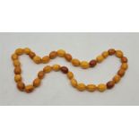 A string of butterscotch amber oval beads, sizes 21mm x 16mm to 17mm x 14mm, overall length