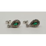 A pair of precious white metal, emerald and diamond drop earrings, each having single round