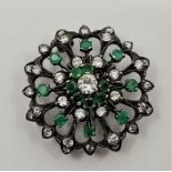 A white and yellow metal, emerald and diamond set brooch, the domed open work circular mount set