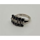 An 18ct. white gold, diamond and sapphire ring, set row of five round brilliant cut diamonds with