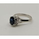A platinum, sapphire and diamond ring, claw set oval mixed cut sapphire to centre and single round