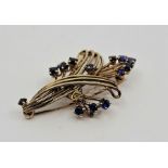 A 9ct. gold and sapphire floral spray brooch, set thirteen mixed round cut sapphires, length 4.