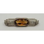 An Art Deco 18ct. white gold, citrine and diamond brooch, having angular pierced and chased mount