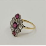 A yellow white metal, diamond and ruby ring, the lobed lozenge form mount set mixed round cut ruby