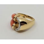 A 14ct. gold, pink coral and diamond ring, of unusual design, having open work centre with