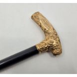An early 20th century yellow metal handled presentation ebony walking stick, the yellow metal handle