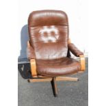 G-Plan - A brown leather swivel chair with wooden back and cross shaped legs. Approx. 94cm high x