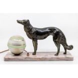 An Art Deco table lamp modelled as a spelter figure of a hunting dog next to globe shaped shade, all