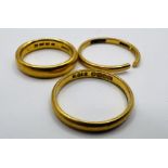 Three 22ct gold wedding band rings - one with a cut shank. Total approximate weight 10.6 grams.