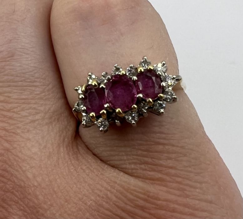 An 18ct gold Ruby and diamond cluster ring. featuring three mixed cut, oval shape rubies and 16 - Image 4 of 4