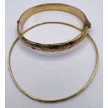 A 9ct gold hinged bangle, with a second unmarked yellow metal bangle. The 9ct bangle has an