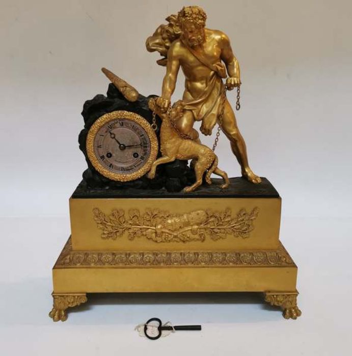 A mid 19th century French bronze and ormolu mantel clock of Hercules and Cerberus, raised on lion