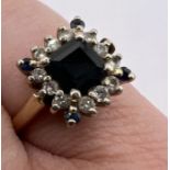 A sapphire and diamond cluster ring. Stamped "14k". Approximate gross weight 4.6 grams.