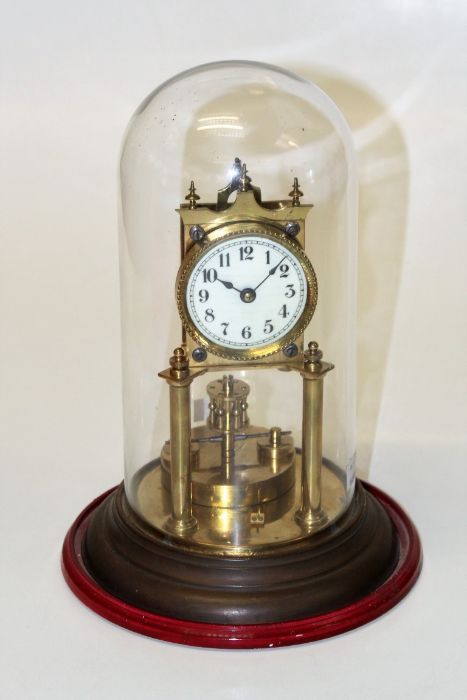 An early 20th German brass anniversary clock, with simulated ivory Arabic dial, on a stepped