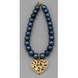 A blue pearl bracelet(treated pearls) with a yellow metal clasp and heart ' tree of life' motif