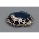 A silver, silver gilt and agate brooch, decorated with a game dog and pheasant in a landscape.