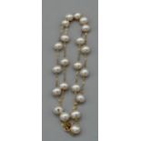 A white pearl and 14k stamped yellow metal necklace. Pearls have off round shape, high lustre with a