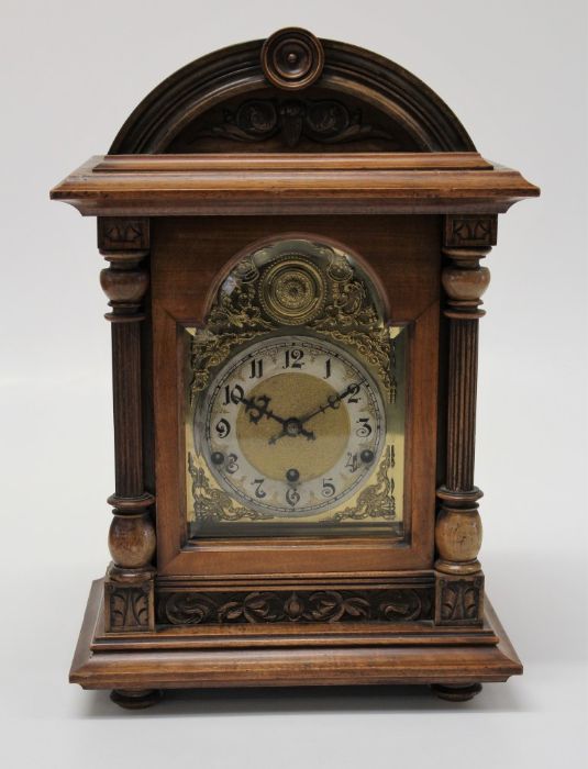 A late 19th century German mantle clock, the domed walnut case enclosing an eight day gong