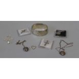 A selection of 20th century silver and white metal featuring a 34.9gm hinged bangle, three pendants,