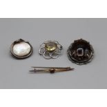 A selection of brooches, featuring a yellow metal garnet set bar brooch, marked ct, in a vintage