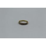 A channel set diamond half eternity ring in yellow metal. Stamped 18k/750.Gross weight approximately
